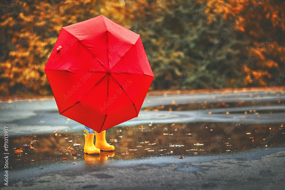 happy child girl with an umbrella and rubber boots in puddle on autumn walk  Stock Photo | Adobe Stock