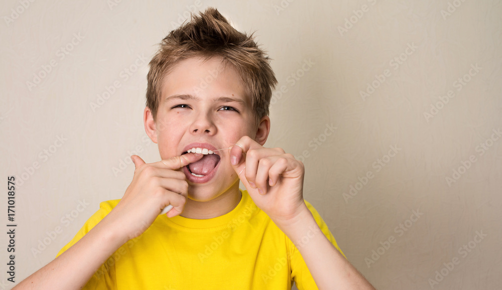 Boy flossing teeth. Close-up portrait of teen boy with dental floss isolated. Boy flossing teeth. Close-up portrait of teen boy with dental floss isolated.