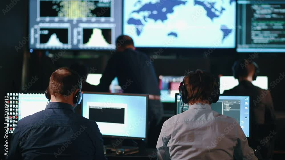 custom made wallpaper toronto digitalClose-up of Operations Engineer Working on His Computer With Multiple Displays in Monitoring Room. In the Background His Colleagues with Graphics and Various Data on Their Monitors.