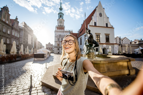 Porait of a young woman tourist traveling on the old Market sqaure in Poznan city during the morning light in Poland photo