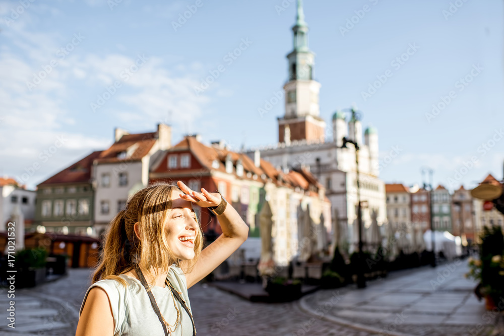 Porait of a young woman tourist traveling on the old Market sqaure in Poznan city during the morning light in Poland