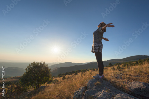 Young woman feel free on beautiful mountain at sunset