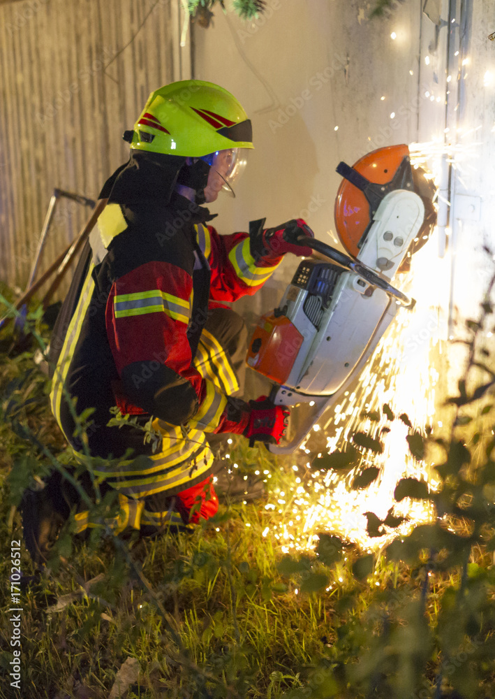 Fototapeta premium Feuerwehrmann öffnet Tür mit Flex