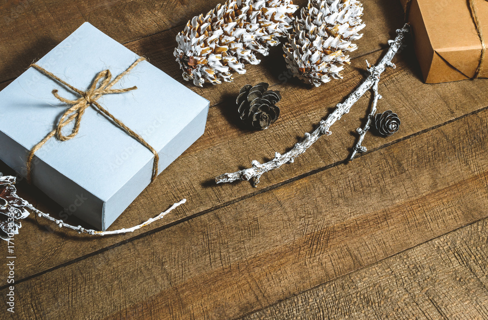 Fototapeta premium Boxes with gifts, cones, free space on a wooden background