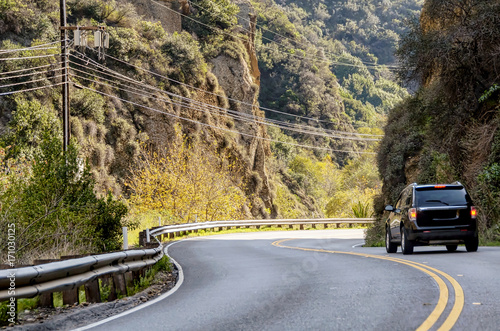 Black car driving along curvy California highway photo