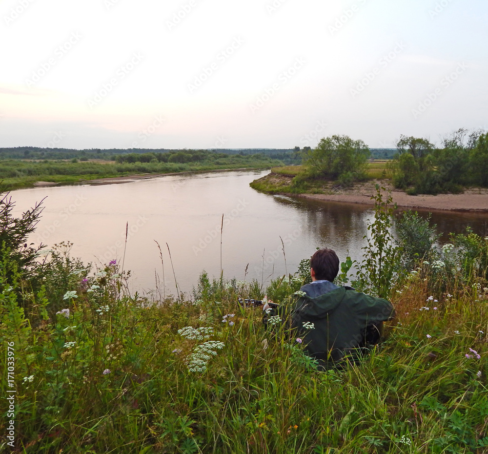 Fototapeta premium A lone guitarist on a river bank