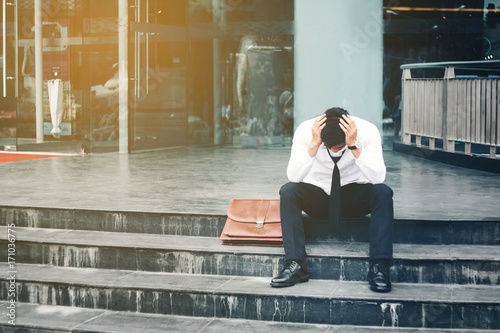 Foto Unemployed Tired or stressed businessman sitting on the walkway after work Stres