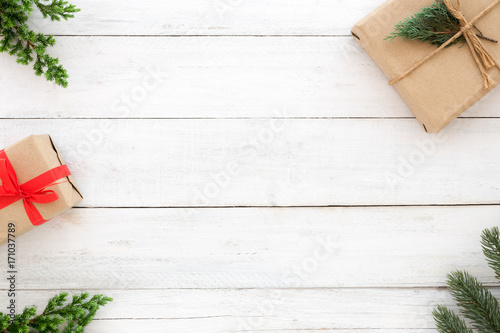 Christmas and New Year background. Christmas present gift boxes and fir leaves decoration rustic elements on white wood background. Creative flat lay, top view design