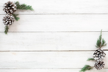Christmas background. Christmas frame made of fir leaves and pine cones decoration rustic elements on white wood board. Creative flat lay, top view design