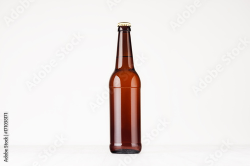 Brown longneck beer bottle mock up. Template for advertising, design, branding identity on white wood table. photo