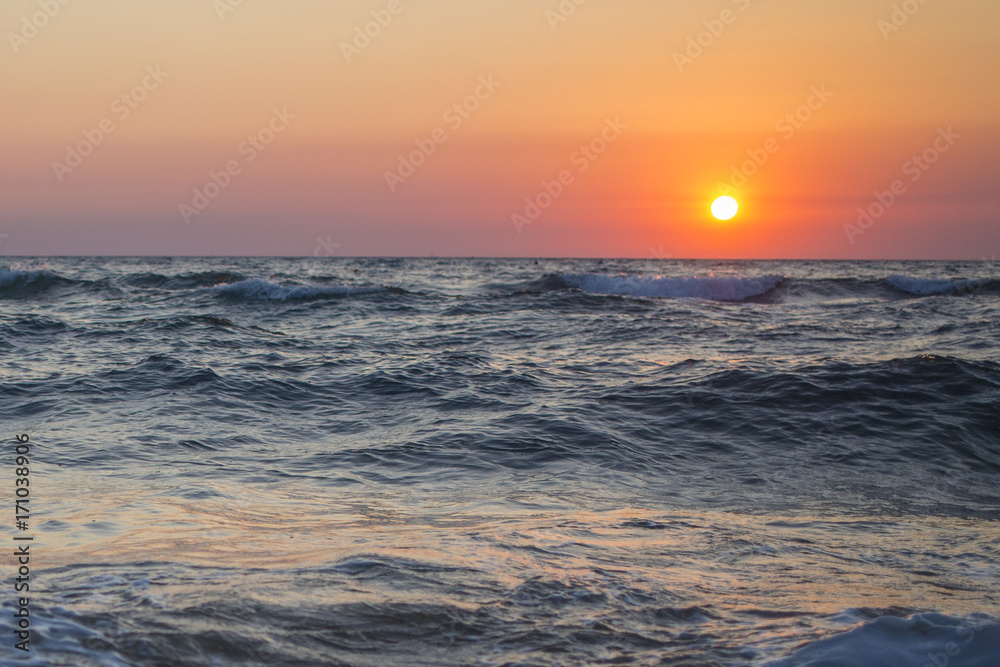 Il sole che tramonta nel mare è sempre una bella chiusura per una giornata di vacanza. Le tonalità calde donate dal sole si scontrano con il blu delle acque agitate del mare.