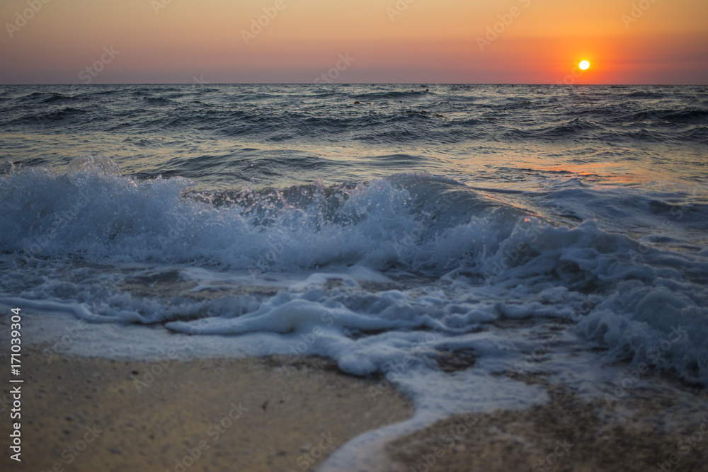 Il sole che tramonta nel mare è sempre una bella chiusura per una giornata di vacanza. Le tonalità calde donate dal sole si scontrano con il blu delle acque agitate del mare.
