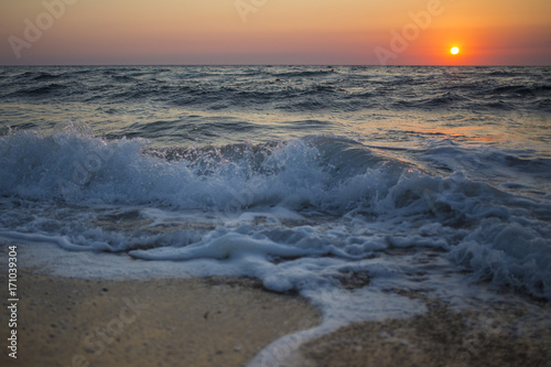 Il sole che tramonta nel mare    sempre una bella chiusura per una giornata di vacanza. Le tonalit   calde donate dal sole si scontrano con il blu delle acque agitate del mare.
