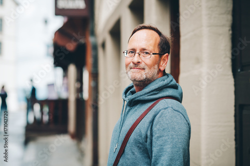 Outdoor portrait of 50 year old man wearing blue hoody and eyeglasses