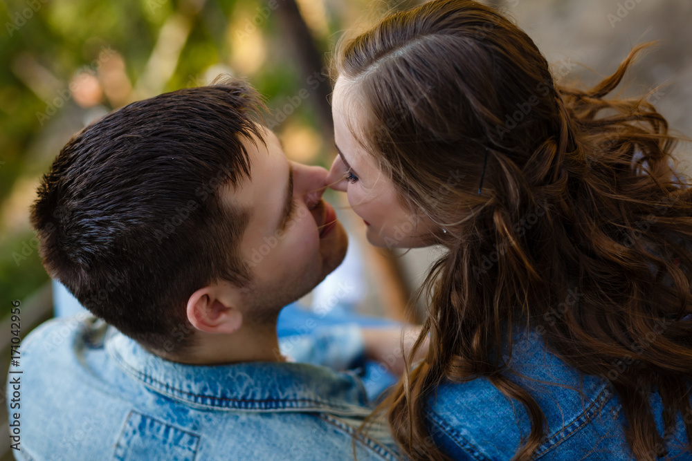 Beautiful couple love kissing while sitting on rocks near river. Wedding couple at sunset and rivers, love and tender feelings. Loving couple resting. Wedding ceremony outdoors. Perfect couple blurred Beautiful couple love kissing while sitting on rocks near river. Wedding couple at sunset and rivers, love and tender feelings. Loving couple resting. Wedding ceremony outdoors. Perfect couple blurred