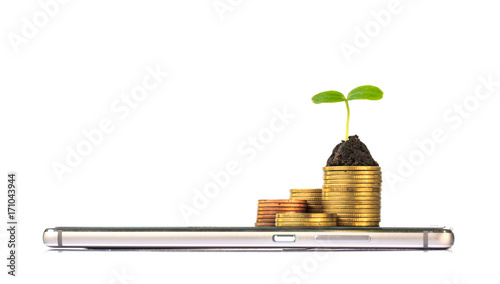 smart phone with stack of coins and seedling on top. business finance concept photo