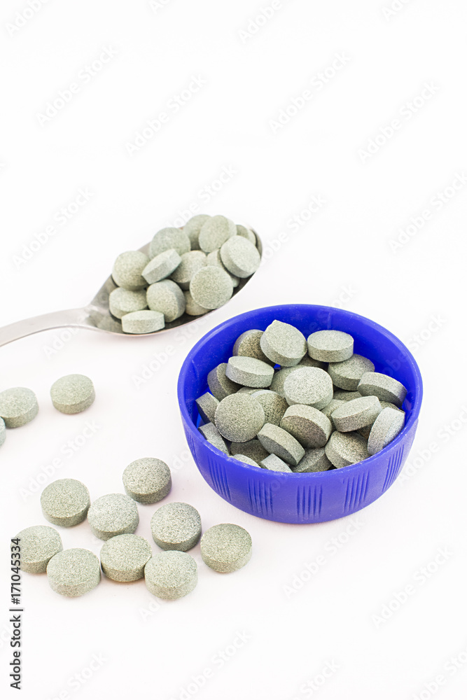 Container, spoon and spirulina pills. Container, spoon and spirulina pills.
