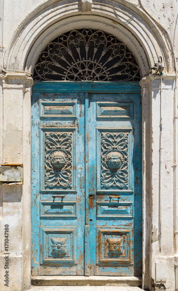 Blue aged Tunisian wooden door with arch and ornament Blue aged Tunisian wooden door with arch and ornament