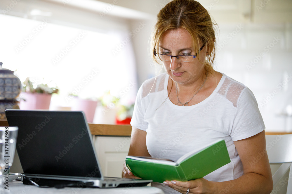 Middle-aged woman using laptop at home Middle-aged woman using laptop at home