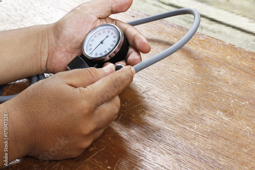 measuring blood pressure with sphygmomanometer
