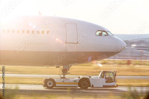 an airplane beeing towed with a modern towing vehicle