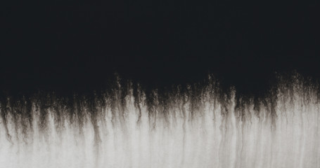 closeup black ink border spreading on wet paper top view