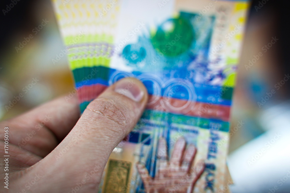 Banknotes of tenge in a hand. A pile of paper Kazakhstan money in the palm of your hand. Theme of corruption or transfer of money.