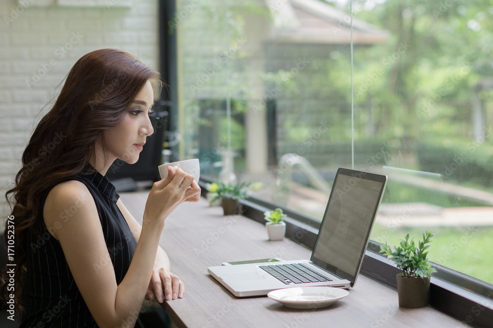 Young business woman working on laptop at office. Young business woman working on laptop at office.