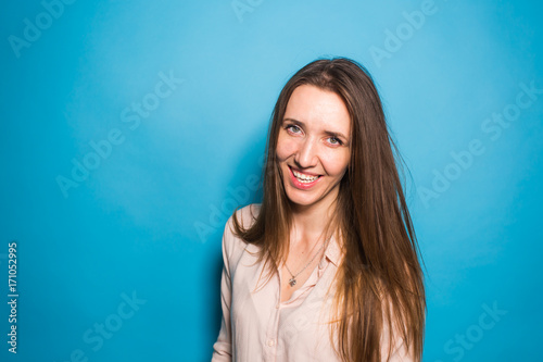 Stylish fashion portrait of casual young beautiful woman on blue background