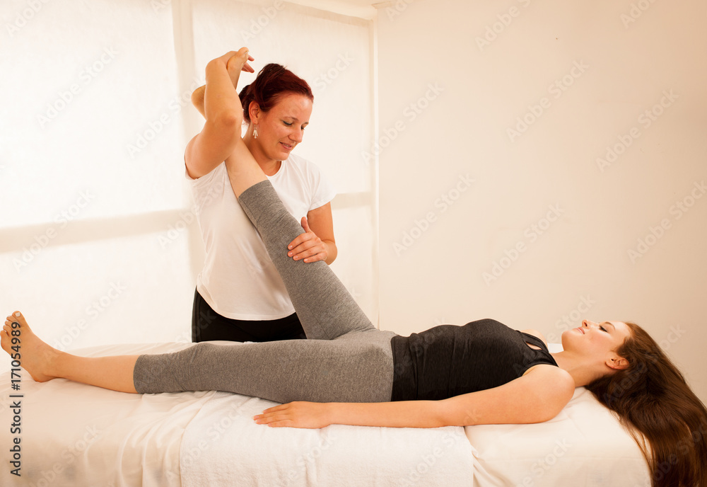 Fototapeta premium physiotherapy -therapist exercising with patient , working on leg stretching