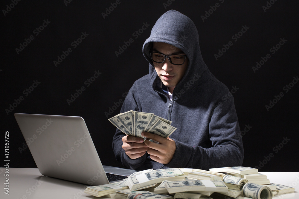Hacker holding Money that Hacking from online in the dark, Man with Hacker Concept. Hacker holding Money that Hacking from online in the dark, Man with Hacker Concept.