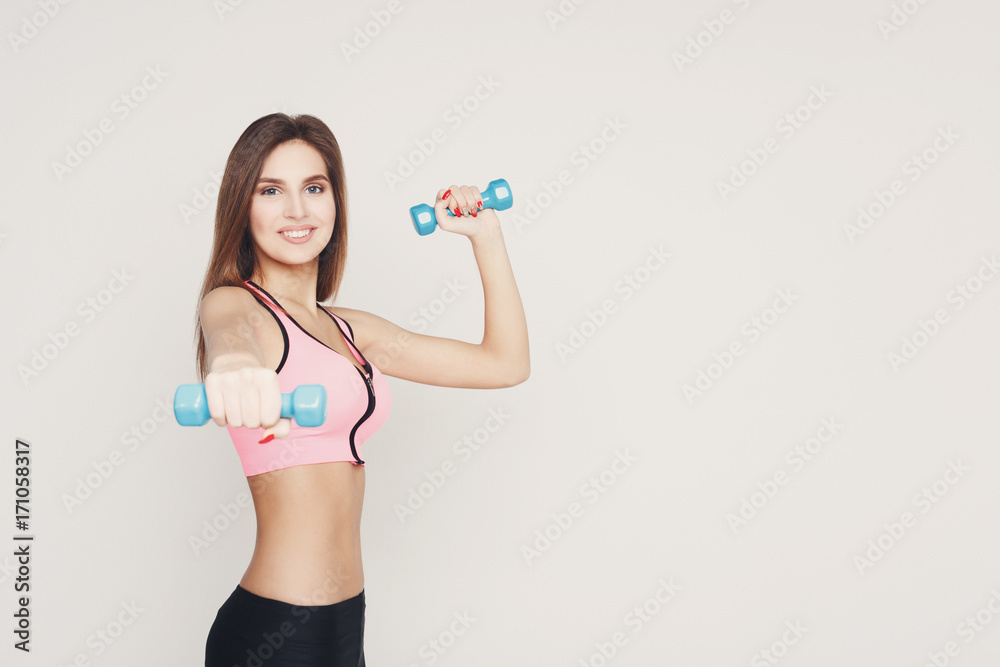 Fitness model woman with dumbbells on white Fitness model woman with dumbbells on white