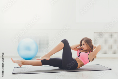 Fitness woman lying doing crunches barefoot