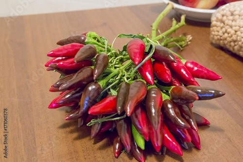 bunch of chillies on wooden kitchen table