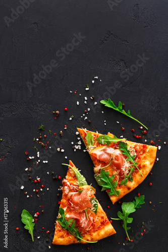 Pizza with prosciutto and rocket salad copy space