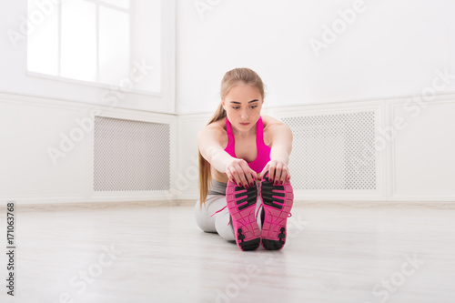 Fitness woman stretching at white background indoors