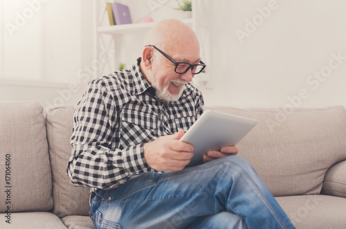 Senior man reading news on digital tablet © Prostock-studio