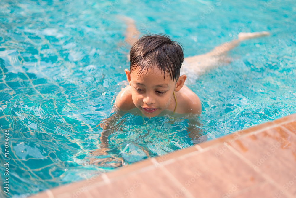 Little asian boy having fun in the pool during summer time. Little asian boy having fun in the pool during summer time.