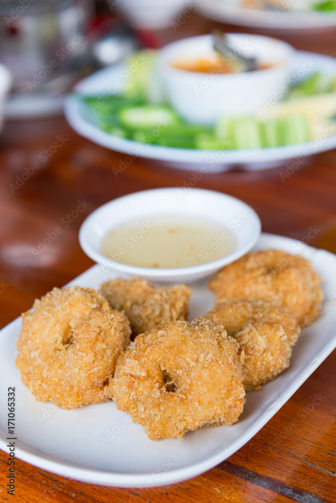 Deep-fried shrimp cakes, served on white dish and served with sweet plum sauce, Thai style appetizers, delicious Thai food. Deep-fried shrimp cakes, served on white dish and served with sweet plum sauce, Thai style appetizers, delicious Thai food.