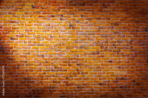Vintage brick wall background with left spotlight on the wall