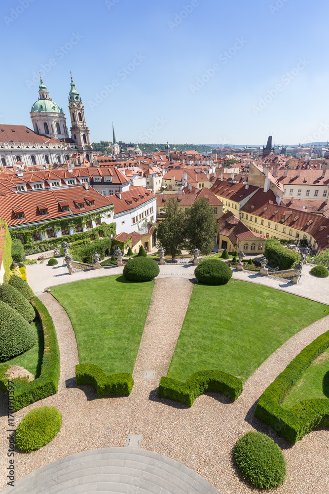 Fototapeta premium View of the Vrtba Garden (Vrtbovská zahrada), St. Nicholas Church and other old buildings at the Mala Strana District (Lesser Town) in Prague, Czech Republic on a sunny day.
