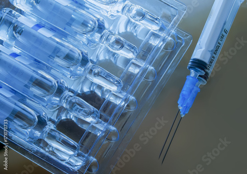 Ampoules packing and syringe. Mirror surface. photo