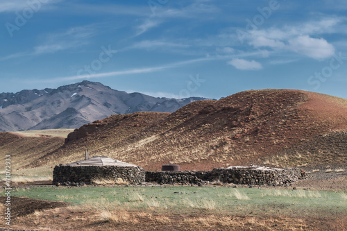 Panoramic view of house on plain with hills and mountains on background 