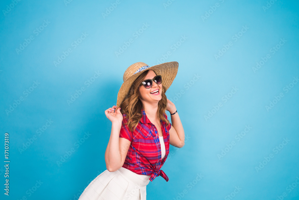Holidays, summer, fashion and people concept - Girl in fashionable clothes straw hat. Portrait of charming woman on blue background with empty copy space