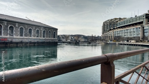 Canvas Print River with Buildings and Rail in foreground.
