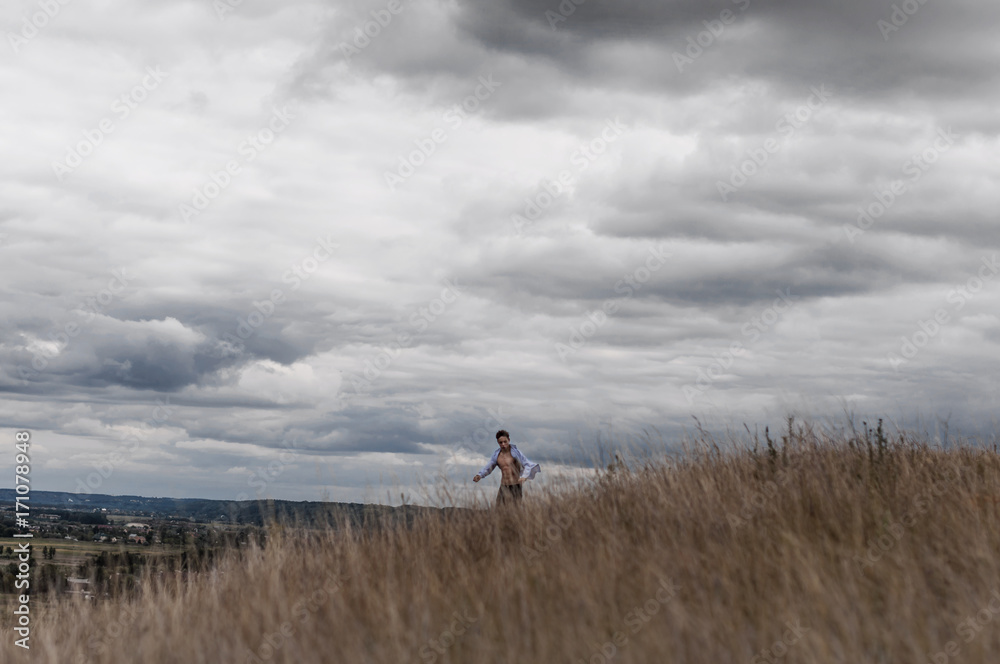man who feels free in a field on a hill man who feels free in a field on a hill