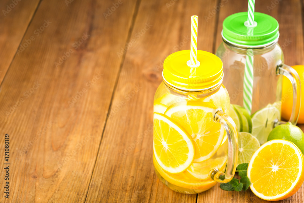 Two jars of detox water with slices of orange and lime. Two jars of detox water with slices of orange and lime.
