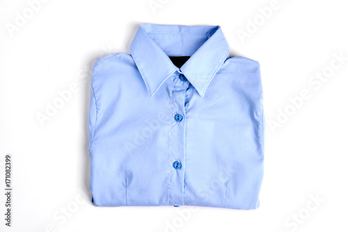 Female light blue formal shirt. New folded cotton woman shirt, white background. Beautiful girls buttoned blouse on sale.