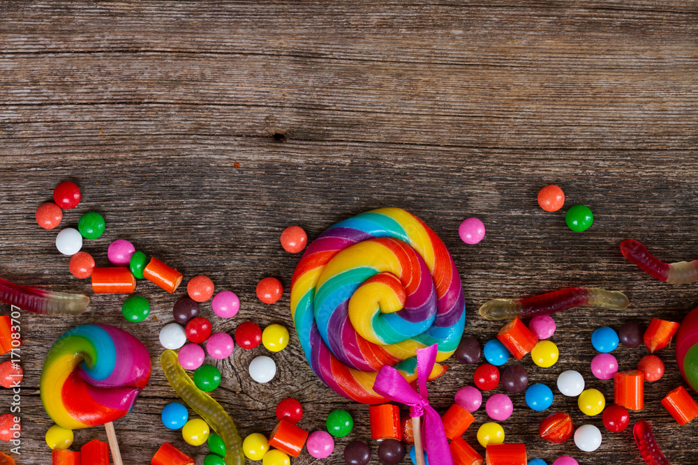 Colorful candies on wooden background with copy space