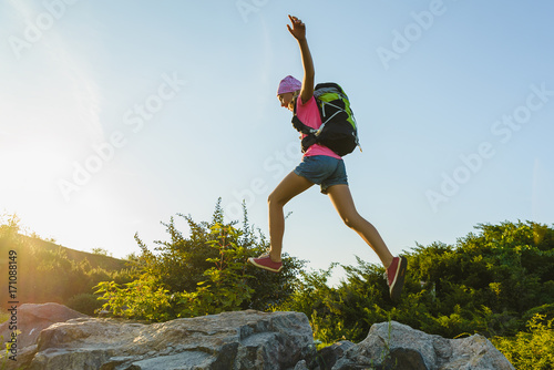 Girl traveler with backpack jumping. Adventure, travel, tourism concept